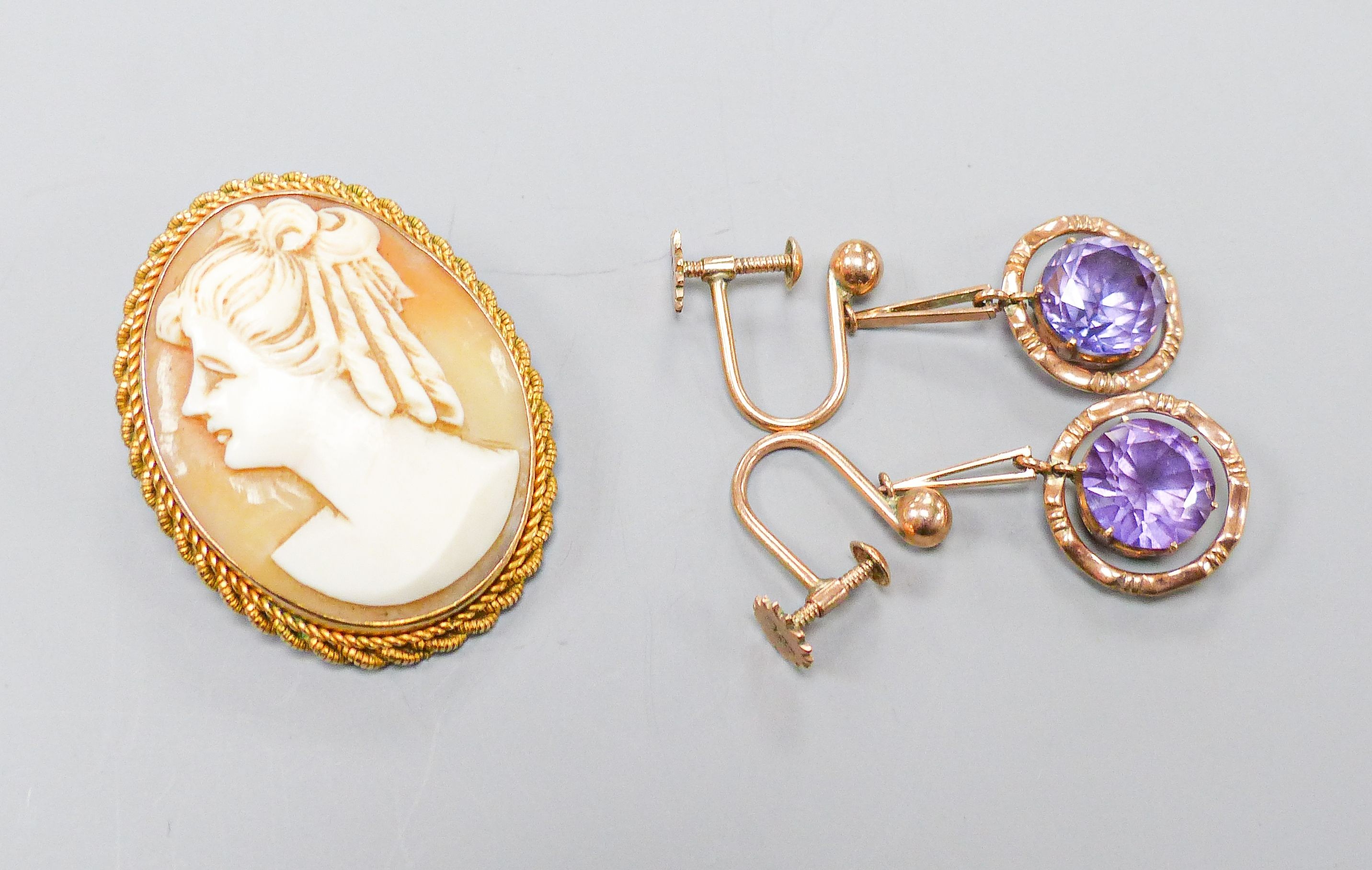 An oval cameo brooch in 9ct mount with rope-twist edge, 35mm and a pair of 9ct drop earrings set with circular synthetic sapphires, gross weight 12.8 grams.